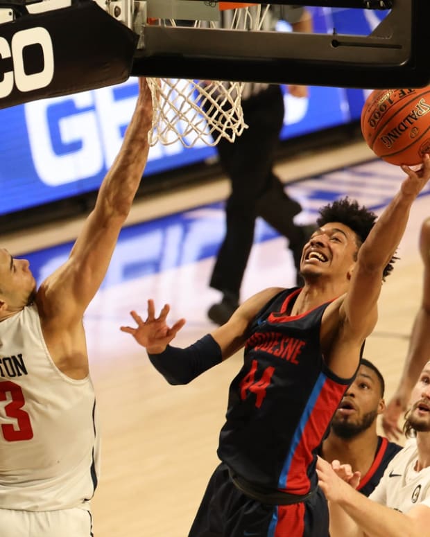 Mar 4, 2021; Richmond, Virginia, USA; Duquesne Dukes forward Chad Baker (44) shoots the ball as Richmond Spiders forward Tyler Burton (3) defends in the second half in the second round of the 2021 Atlantic 10 Conference Tournament at Stuart C. Siegel Center. Mandatory Credit: Geoff Burke-USA TODAY Sports